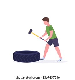 sports man hitting big tire with hummer doing hard exercises guy working out in gym crossfit training healthy lifestyle concept flat white background