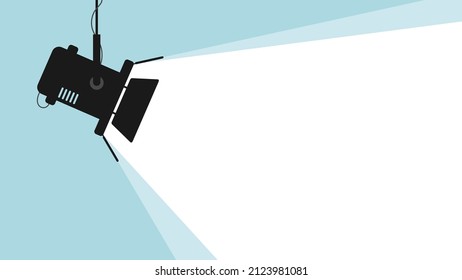 Spotlight black silhouette isolated on blue background. Lamp light projector glowing with scattered rays. Projecting a beam of light with place for text. Cinema background. Template for festive poster