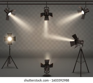 Spotlights realistic vector set. Professional photo and video lamps, hanging and standing on tripod, stage equipment with warm yellow light on transparent background.