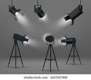 Spotlights for studio or stage. Vector realistic set of glowing floodlights for illumination show, concert or podium. Black spot lamps on stand and hanging on gray background