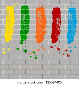 spots of varicoloured paint on a gray  brick wall