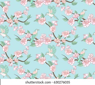 Spring apple or peach tree blossom seamless pattern with flying birds on blue sky background