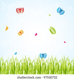 Spring background with multicolored butterflies under fresh green grass