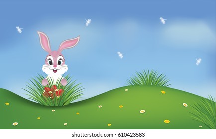 Spring background with a pink cute bunny and red Easter eggs in a green field. Dragonflies on the blue sky.