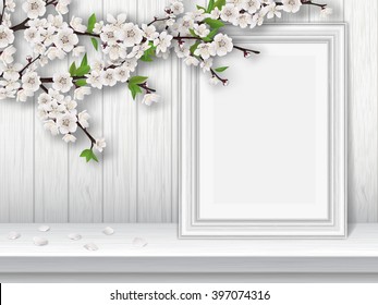 Spring blooming cherry branch and photo frame on a white table. Spring vintage interior decor. Vector greeting card template.