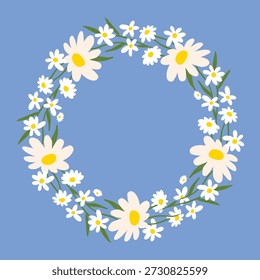 Corona floral de primavera hecha de margaritas en flor y hojas verdes sobre un fondo azul. Composición botánica circular en estilo plano. Adecuado para tarjetas de felicitación y diseños de temporada.