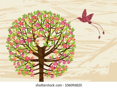 Spring green tree with pink flowers and flying hummingbird