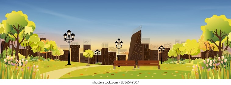 Spring landscape at city park in the morning, Natural public park with flowers blooming in the garden, Peaceful scene of green fields with blurry cityscape building, cloudy and sun on summer