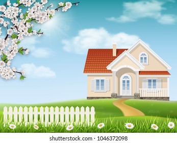 Spring landscape. Country house on a hill. Grass and flowering tree branches in the foreground.