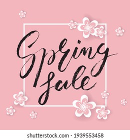 Spring Sale brush lettering on pink background with sakura flowers in paper-cut style. Template for sale card, banner, wallpaper, voucher, poster, flyer. Vector illustration. EPS10