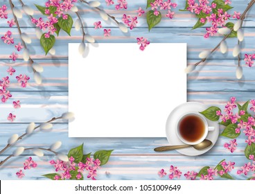 Spring top view wooden background with a cup of tea, flowers, blank piece of paper and pussy willow branches