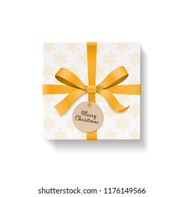 Square gift box, gold color bow knot and ribbon with circle kraft hang tag. Yellow snowflake pattern paper. Merry Christmas text on ball. Happy New Year package. Vector illustration 3d top view