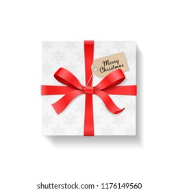 Square gift box, red color bow knot and ribbon with kraft hang tag. Snowflake pattern paper. Merry Christmas text. Happy New Year package concept. Closeup Vector illustration 3d top view