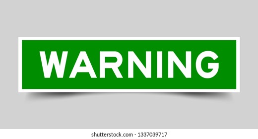 Square green sticker label in word warning on gray background