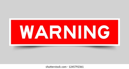Square red sticker label in word warning on gray background