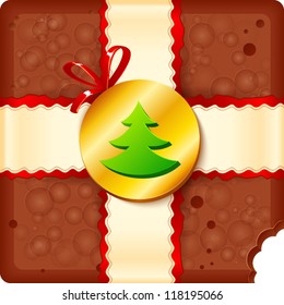 Squared piece of aerated chocolate with ribbons and badge with christmas tree