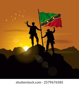 ST. Kitts Nevis flag, silhouette of two climbers holding flags at sunset