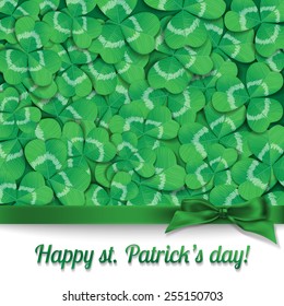 St. Patrick day card. Green silk bow on background covered with clovers and white card with lettering.
