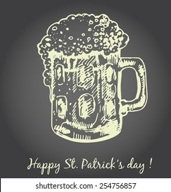 St. Patrick day card, hand- drawn glass of beer with foam and lettering on chalkboard background.