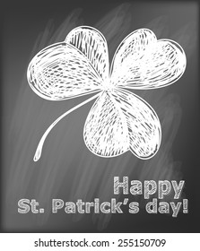  St. Patrick day card. Hand- drawn three leaf clover and lettering  on  chalkboard background.