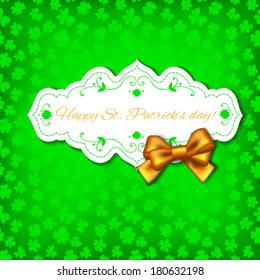 St. Patrick day card, white paper label with floral decoration and orange bow on green background with clover pattern