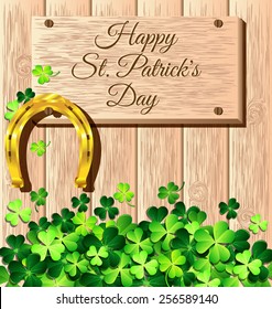 St. Patrick's Day frame with gold horseshoe on wooden wall