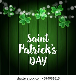 St. Patrick's day green wooden background with strings of lights and shamrocks. Party decoration. Vector illustration, web banner.