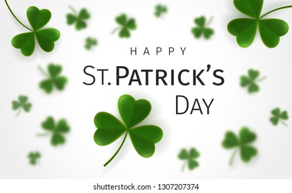 St. Patrick's Day greetings card with flying clover leaves on a white background. Leaves on backdrop are blurred. Irish traditional holiday 