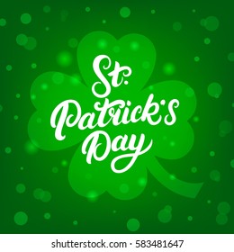 St. Patrick's Day hand written lettering on green clover leaf background. Modern brush calligraphy for greeting card and poster. Vector illustration.