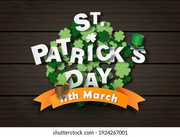 St. Patrick's Day lettering with high hat and tobacco pipe on the day of event's ribbon, clovers and brown wooden board background. St. Patrick's Day greeting card in paper cut and vector design.
