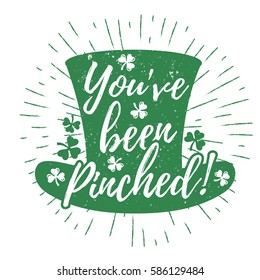 St. Patrick's Day quote typography lettering greeting card template on a grunge texture green leprechaun's hat with lucky shamrock clover for print, t-shirt, design element. You've been pinched