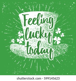 St. Patrick's Day quote typography lettering greeting card template on a grunge texture green shape with lucky shamrock clover for print, t-shirt, festive design element. Feeling lucky today