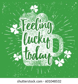 St. Patrick's Day quote typography lettering greeting card template on a grunge texture green shape with lucky shamrock clover for print, t-shirt, festive design element. Feeling lucky today