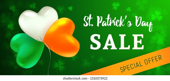 St Patrick's Day Sale. Glossy heart-shaped balloons painted in the colors of the Irish flag. Blurred background with leaves of shamrock. Design concept for advertising banner, poster or flyer.