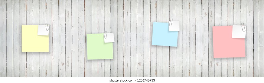 Stack of colored stickers attached metal paper clip with curled corner, ready for your message. Set of color stickers isolated on white wooden boards wall background. illustration set paper Front view