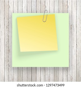 Stack of colored stickers attached metal paper clip with curled corner, ready for your message. Set of color stickers isolated on white wooden boards wall background. illustration set paper Front view