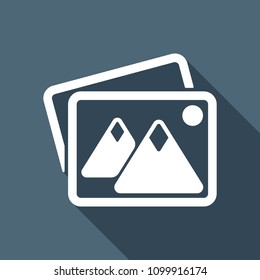 Stack of pictures with couple of mountains and sun. Simple icon. White flat icon with long shadow on background