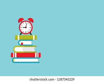 stack of turquoise books with red alarm clock.  Isolated on powder blue background. 