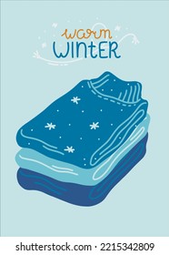 A stack of warm knitted sweaters for the cold season. Folded sweaters in blue colors with warm winter lettering. Design element. Vector illustration in a flat style.