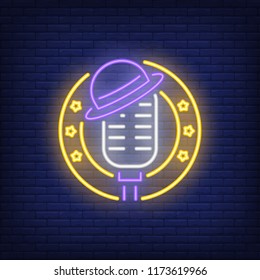 Stage neon icon. Mic with hat in circle frame with stars on brick wall background. Show concept. Vector illustration can be used for neon signs, advertising, stand up show