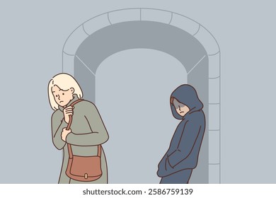 Stalker is watching woman walking along dark street, standing near arch in hood. Stalker chooses moment to rob and attack frightened victim in order to take purse with money and price of things