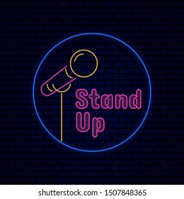 Stand up comedy title board sign logo badge with microphone icon. Retro glowing neon light effect for night entertainment vector illustration on dark brick background design