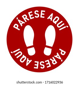 Párese Aquí ("Stand here"auf Spanisch) Rundböden-Markierungsstand hier Symbol mit Text und Shoeprints für Warteschlange oder andere Zwecke, die soziale Distanz erfordern. Vektorillustration-Bild.