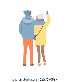 Standing back and embracing man and woman in warm blue hat and jacket with handbag and in colorful trousers and boots. Winter image isolated on white