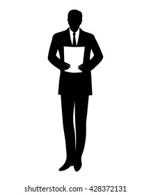 Standing businessman reads document.