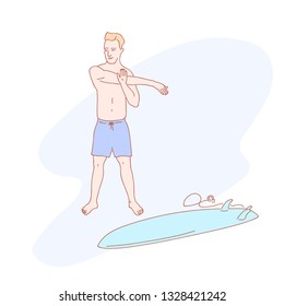 Standing male surfer doing warm up near surfboard