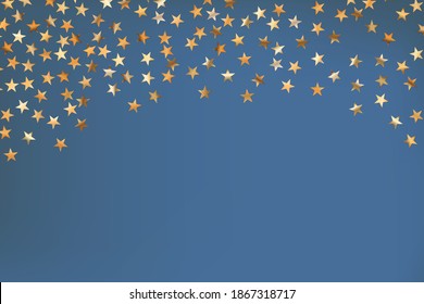 Stars golden glitter confetti isolated on blurred abstract blue background. Festive holiday background. Celebration concept. Falling magic gold  particles. Invitation mock up. Top view, flat lay.