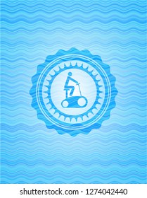 stationary bike icon inside water wave representation badge.