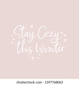 Stay cozy this winter positive lettering vector illustration. Inspirational handwriting phrase in white color with snowflakes on pastel purple background