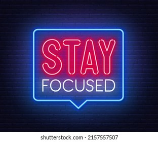 Stay Focused neon lettering on brick wall background.